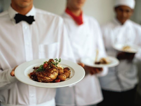 Waiters serving plated dishes